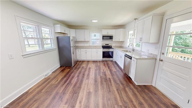 1023 Spring St, Mount Airy, NC 27030 - kitchen with appliances with stainless steel finishes, dark wood-style flooring, light stone counters, and white cabinets