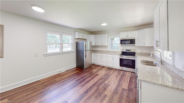 1023 Spring St, Mount Airy, NC 27030 - kitchen featuring appliances with stainless steel finishes, healthy amount of natural light, white cabinets, dark wood finished floors, and recessed lighting