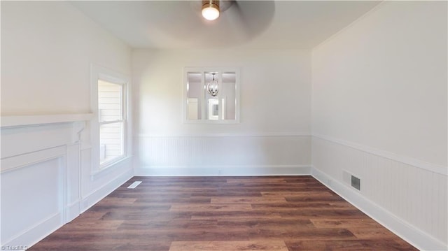 1023 Spring St, Mount Airy, NC 27030 - unfurnished dining area with a chandelier, ceiling fan, wainscoting, and dark wood-type flooring