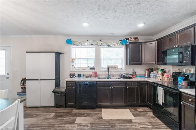kitchen featuring crown molding, a sink, light countertops, a textured ceiling, and black appliances