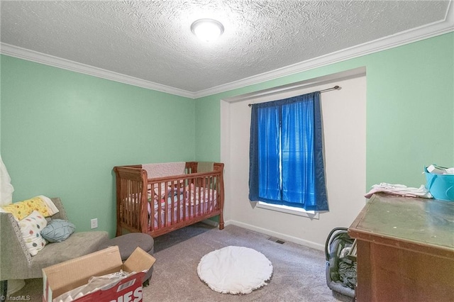 carpeted bedroom featuring a textured ceiling, visible vents, a crib, baseboards, and ornamental molding