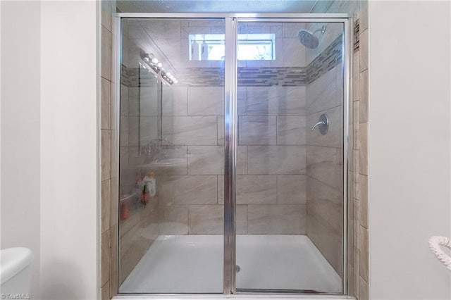 full bath featuring toilet and a stall shower