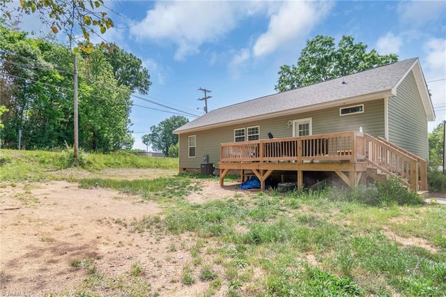 back of property featuring a deck, cooling unit, and roof with shingles