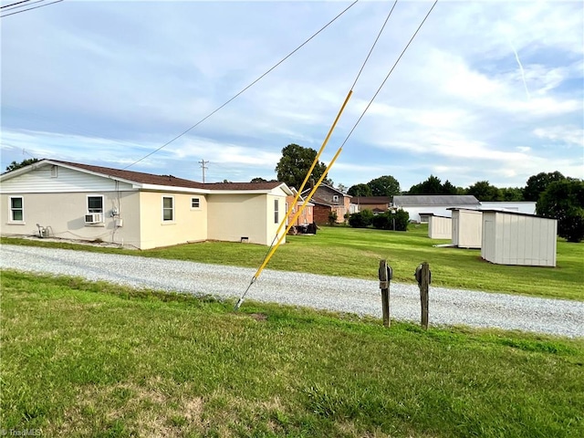 view of property exterior with a storage shed and a lawn