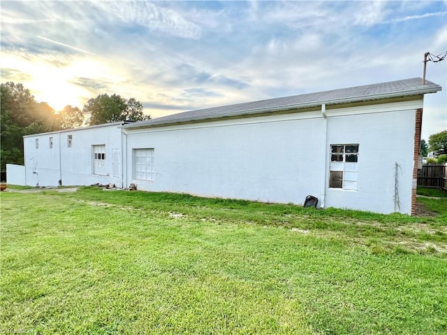 property exterior at dusk with a yard