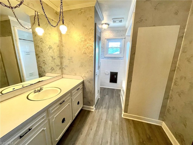 bathroom with hardwood / wood-style flooring, tile walls, vanity, and ornamental molding