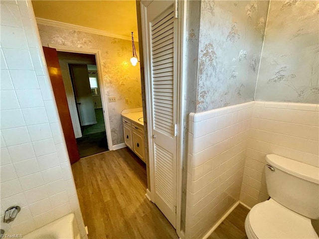 bathroom featuring vanity, crown molding, tile walls, and hardwood / wood-style flooring