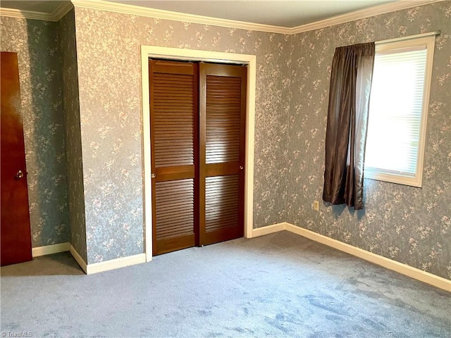 unfurnished bedroom featuring carpet flooring, crown molding, and a closet