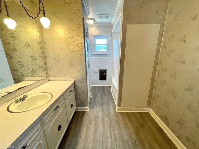 bathroom featuring vanity, shower / bath combo with shower curtain, hardwood / wood-style flooring, and ornamental molding