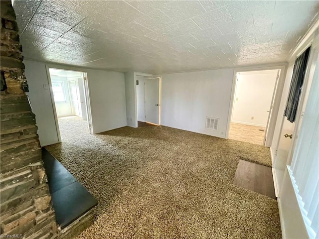 spare room featuring carpet and a textured ceiling