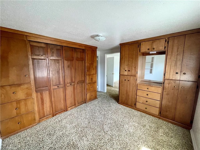 unfurnished bedroom featuring a textured ceiling, wooden walls, and light colored carpet