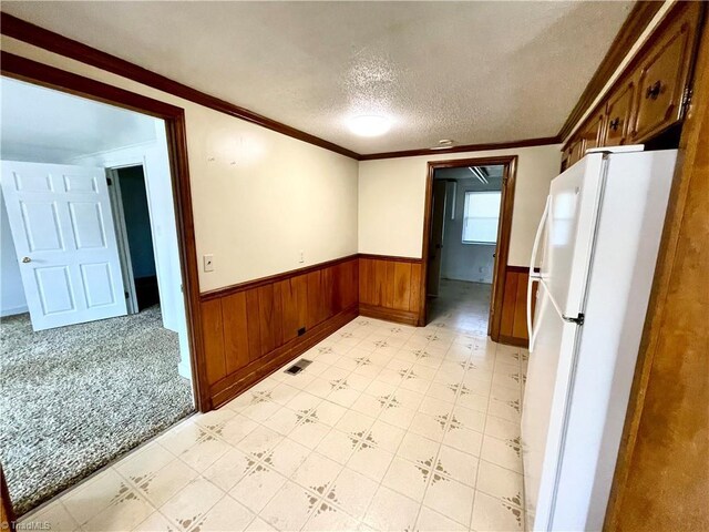 6327 Blazing Star Dr, Archdale, NC 27263 - kitchen featuring wood walls, wainscoting, a textured ceiling, freestanding refrigerator, and light floors