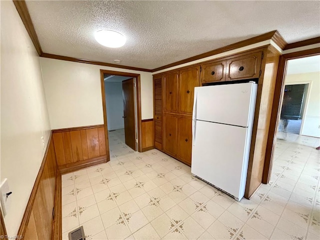 6327 Blazing Star Dr, Archdale, NC 27263 - kitchen with visible vents, crown molding, light floors, wainscoting, and freestanding refrigerator