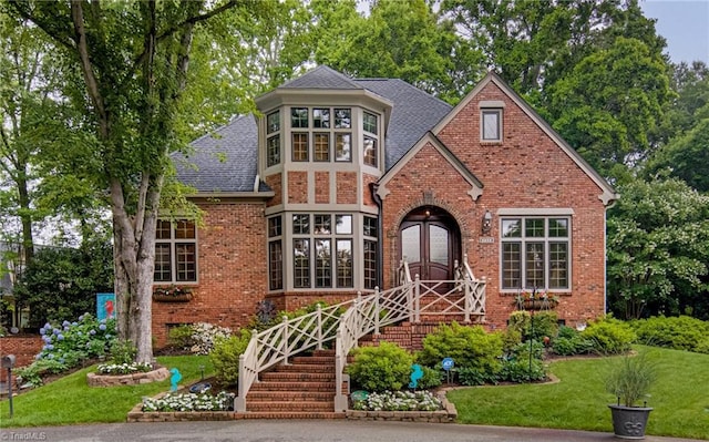 3705 Bradwyck Cir, Winston-Salem, NC 27104 - tudor house featuring brick siding, roof with shingles, and a front yard