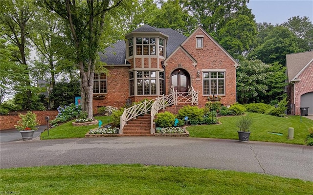 3705 Bradwyck Cir, Winston-Salem, NC 27104 - tudor-style house with a front yard, brick siding, and roof with shingles