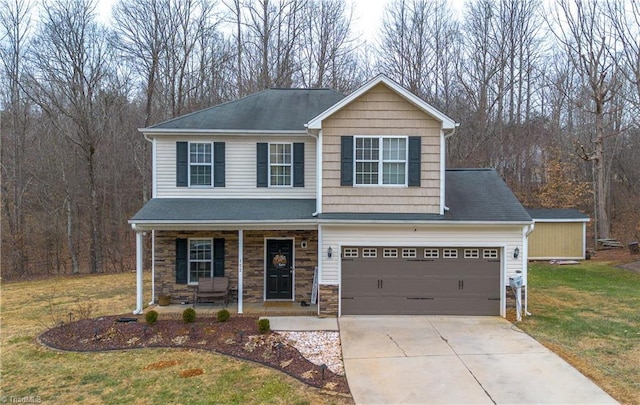 view of front facade featuring a garage, a front lawn, and covered porch