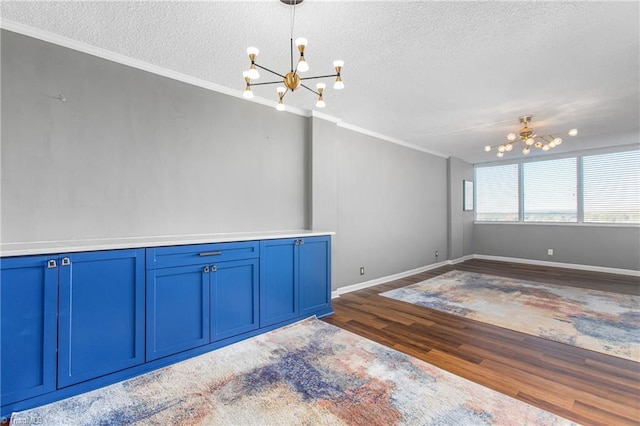 spare room with crown molding, dark hardwood / wood-style floors, a chandelier, and a textured ceiling