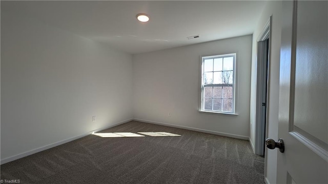 spare room with dark colored carpet