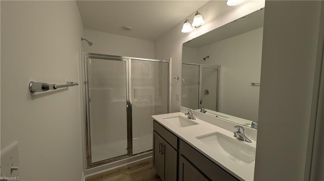 bathroom with hardwood / wood-style floors, vanity, and a shower with shower door