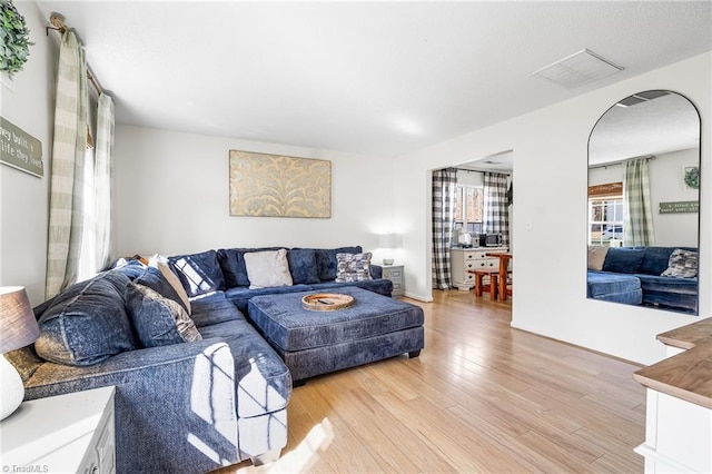 living area featuring light wood-type flooring and visible vents