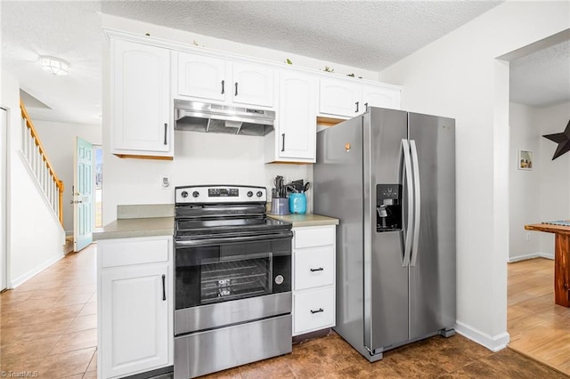 kitchen with a textured ceiling, stainless steel appliances, white cabinets, and under cabinet range hood