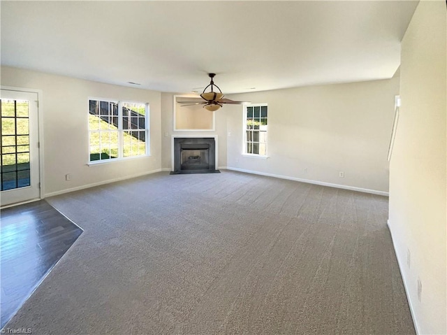 unfurnished living room with carpet flooring and ceiling fan