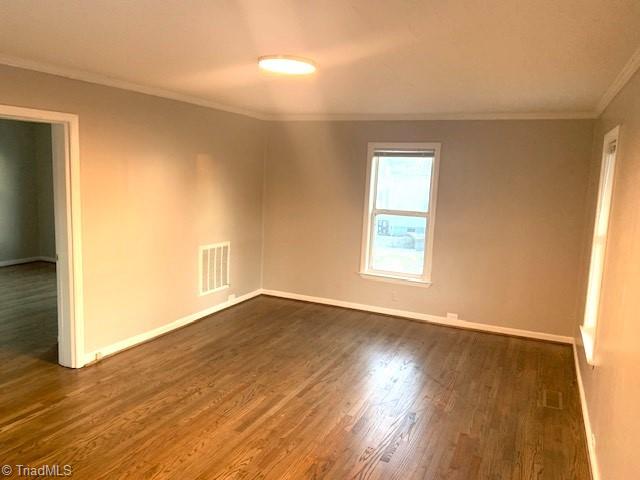 unfurnished room featuring crown molding and dark hardwood / wood-style floors