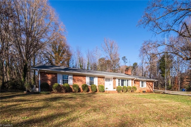 single story home featuring brick siding, a chimney, and a front lawn