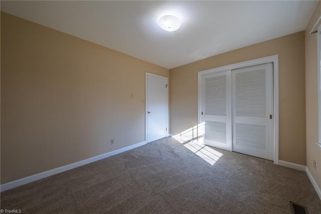 unfurnished bedroom with visible vents, carpet floors, baseboards, and a closet