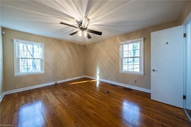 unfurnished room featuring visible vents, a ceiling fan, baseboards, and wood finished floors