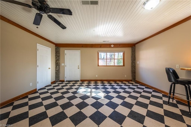 interior space with crown molding, visible vents, baseboards, and ceiling fan