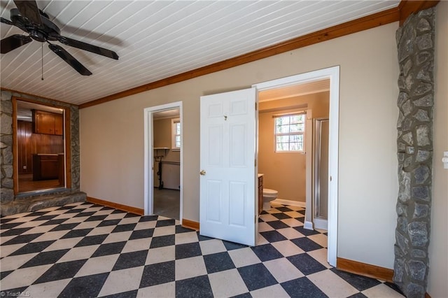 interior space with tile patterned floors, a ceiling fan, and baseboards