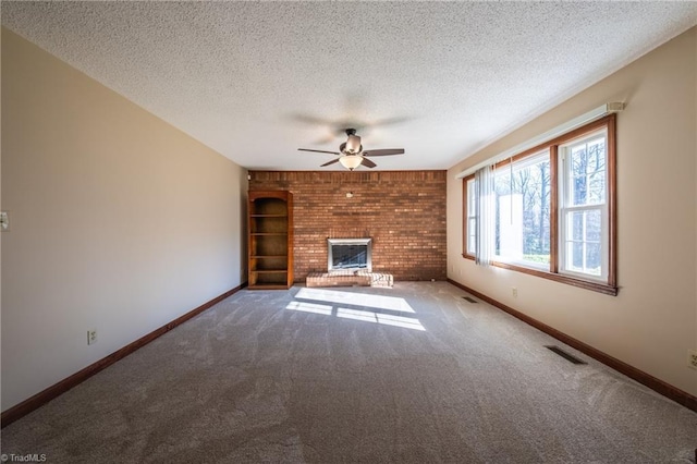 unfurnished living room with visible vents, a ceiling fan, a textured ceiling, a fireplace, and baseboards