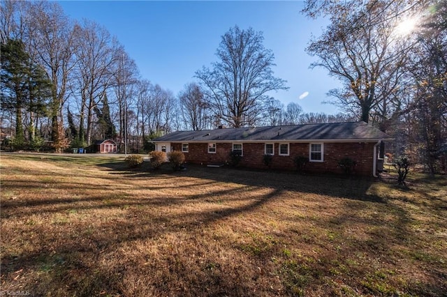 back of house featuring an outbuilding and a lawn