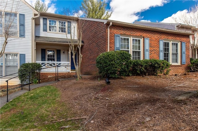 view of front of home with a porch and brick siding