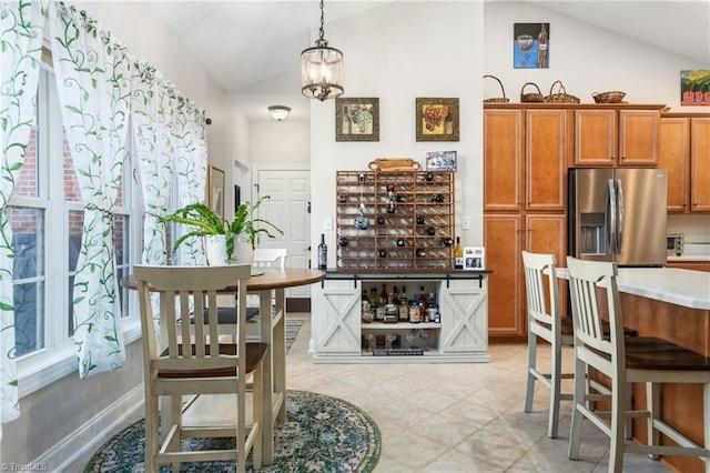 kitchen with stainless steel fridge with ice dispenser, an inviting chandelier, lofted ceiling, and decorative light fixtures