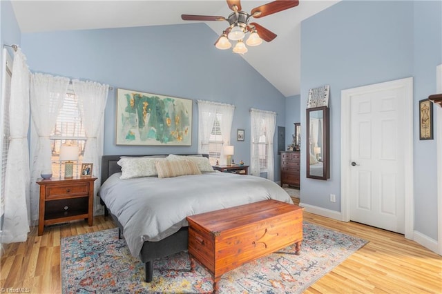 bedroom featuring light wood-type flooring, ceiling fan, and high vaulted ceiling