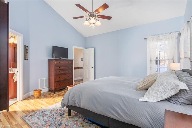 bedroom with ceiling fan, ensuite bathroom, light hardwood / wood-style floors, and high vaulted ceiling