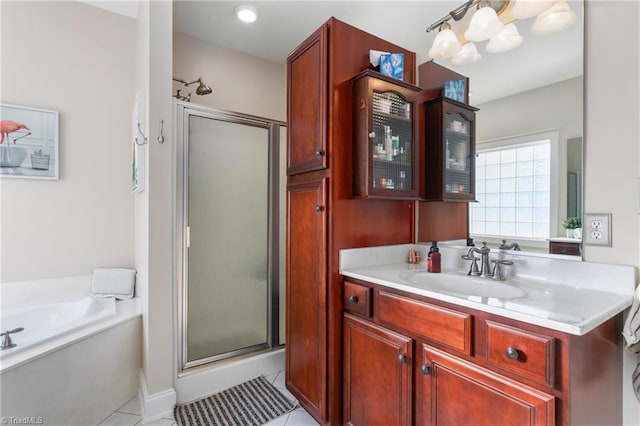 bathroom with plus walk in shower, vanity, and tile patterned flooring