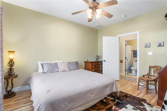 bedroom featuring ceiling fan, light hardwood / wood-style floors, and connected bathroom