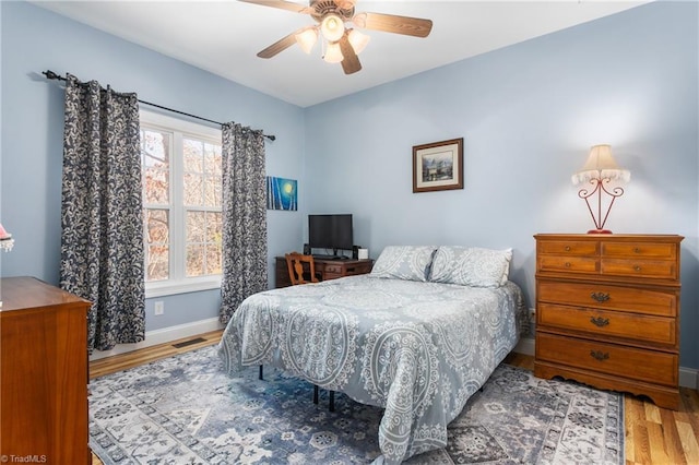 bedroom with ceiling fan and hardwood / wood-style flooring