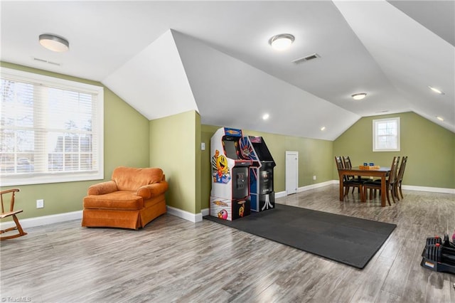 workout room featuring light hardwood / wood-style flooring and lofted ceiling