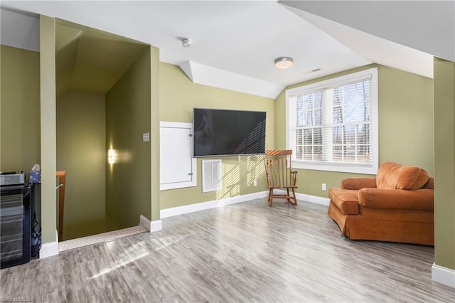 living area featuring lofted ceiling and hardwood / wood-style flooring