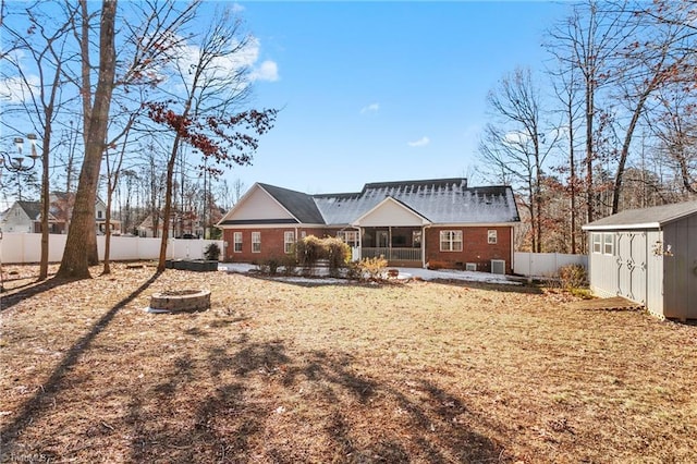 rear view of house with central AC and a storage shed