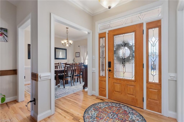 foyer entrance featuring crown molding, a chandelier, and hardwood / wood-style flooring