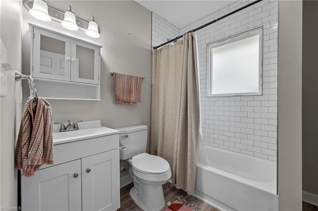bathroom with vanity, toilet, wood finished floors, and shower / tub combo
