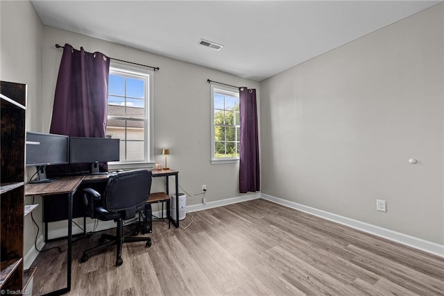office space featuring baseboards, wood finished floors, and visible vents