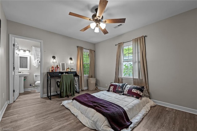 bedroom featuring baseboards, visible vents, and wood finished floors