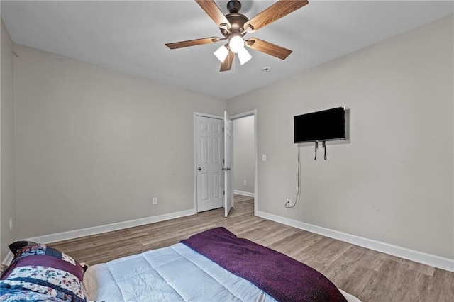 bedroom with baseboards, ceiling fan, and wood finished floors