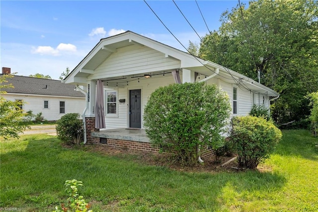 view of front of home featuring covered porch and a front lawn